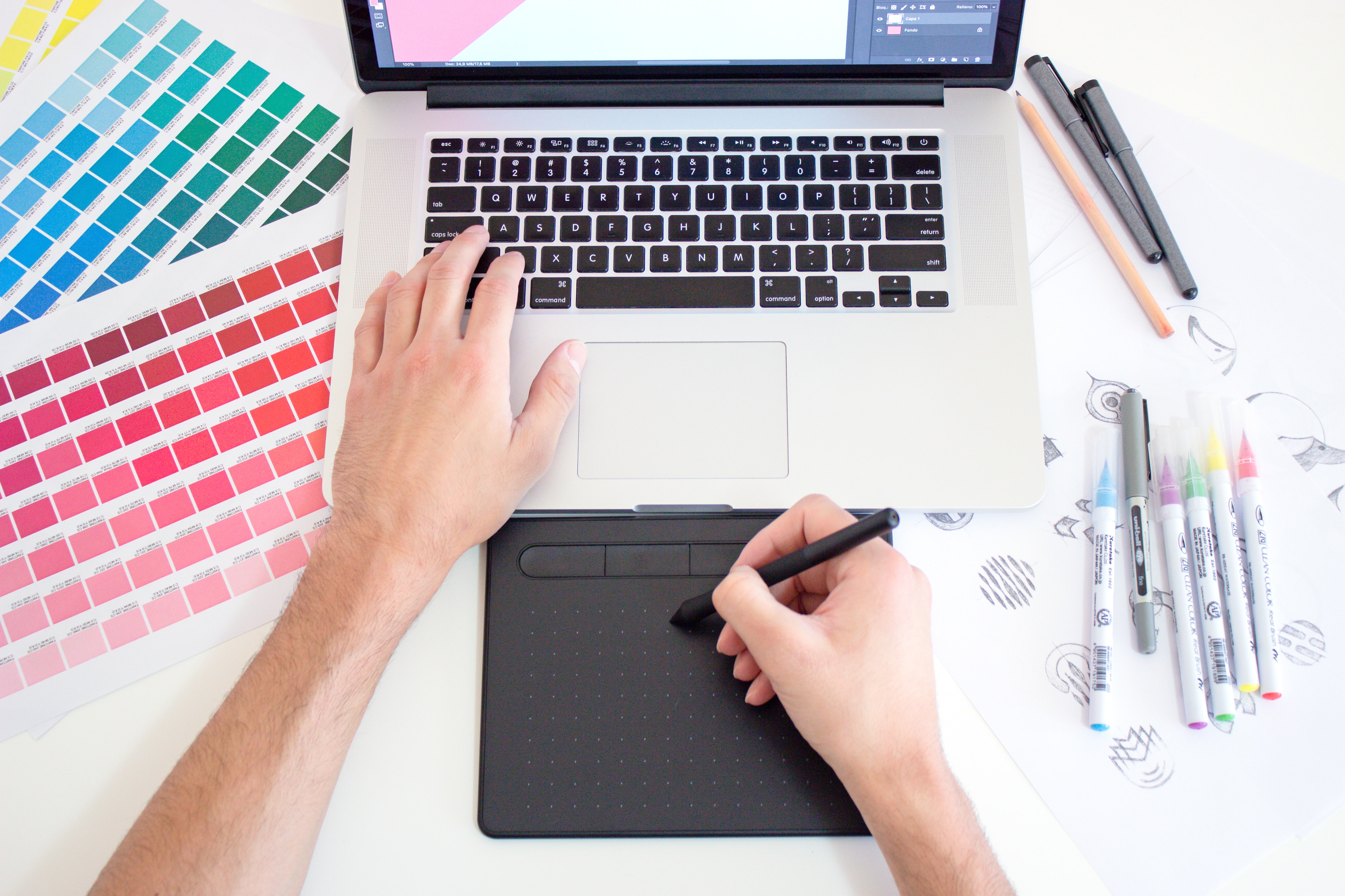 Graphic designer on computer with color swatches